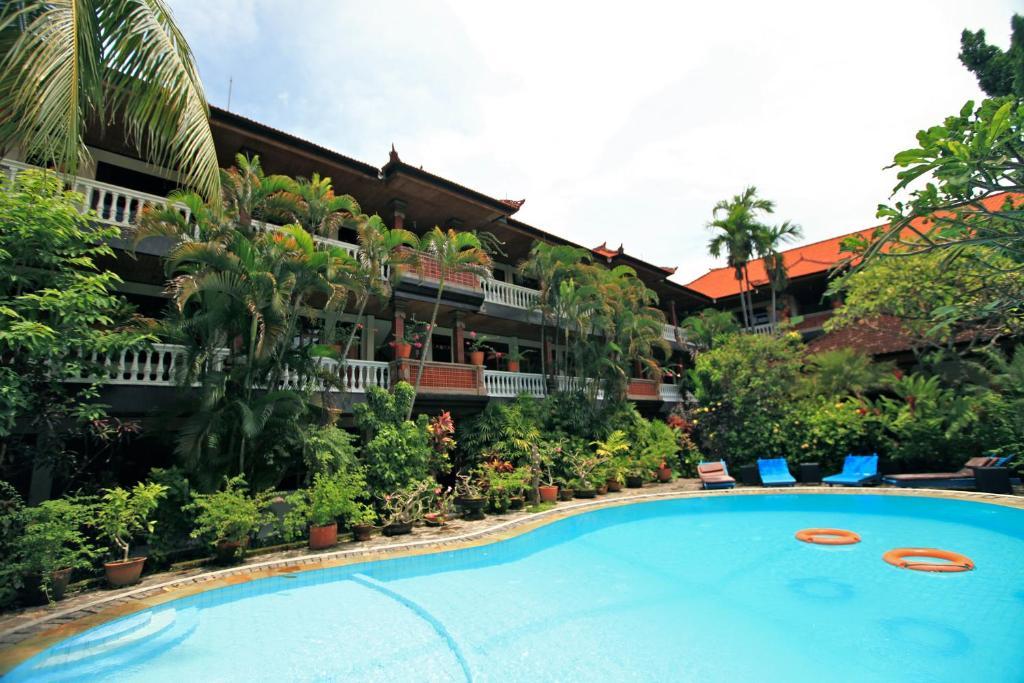 a hotel with a swimming pool in front of a building at Simpang Inn Hotel in Legian