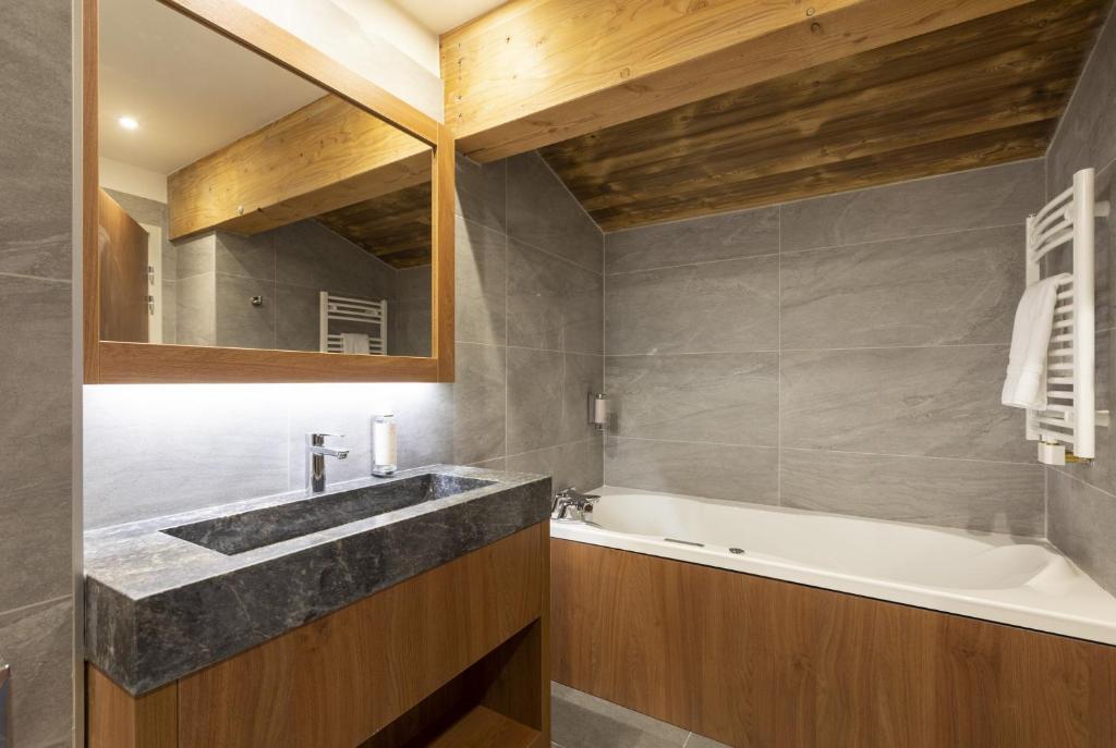 a bathroom with a sink and a bath tub at Les Balcons Platinium Val Cenis in Lanslevillard