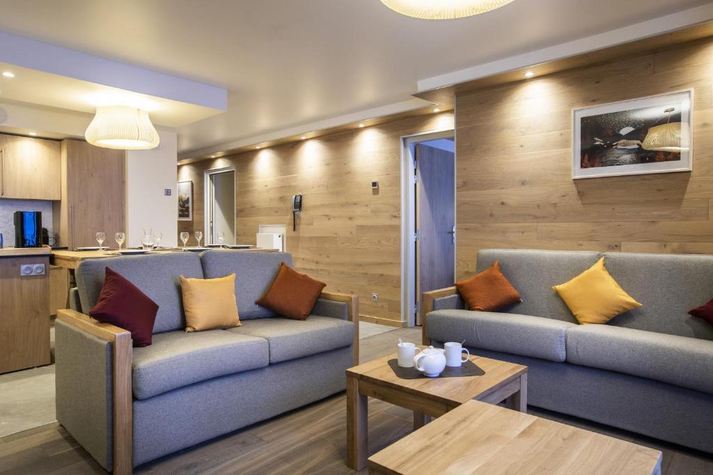 a living room with two couches and a table at Les Balcons Platinium Val Cenis in Lanslevillard