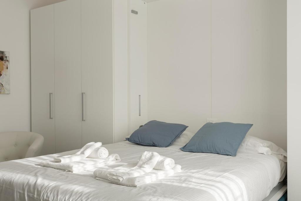 Una cama blanca con toallas encima. en Amazing terrace in Milan- Città Studi en Milán