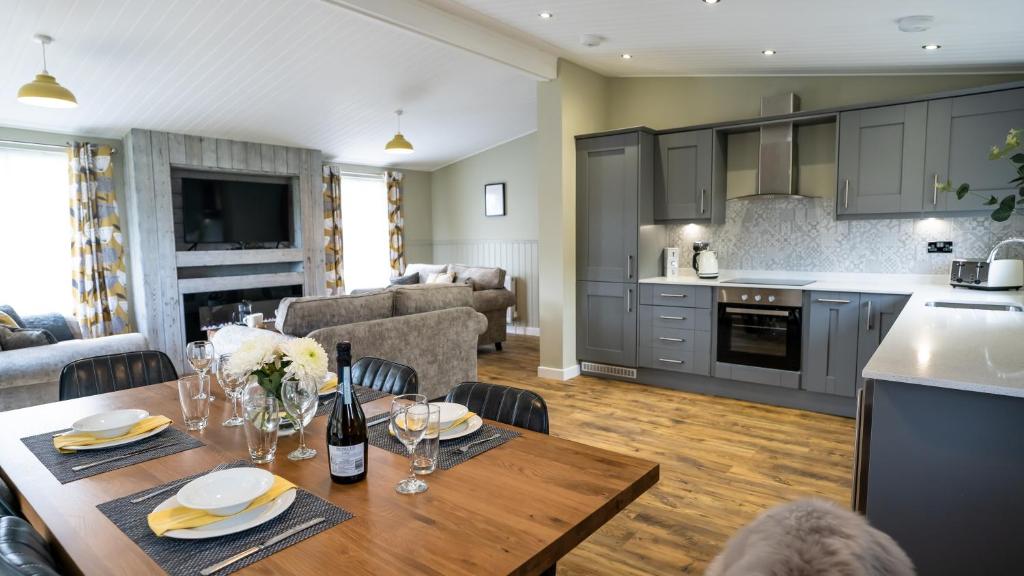 a kitchen and living room with a wooden table and chairs at Chestnut Meadow Country Park in Sidley