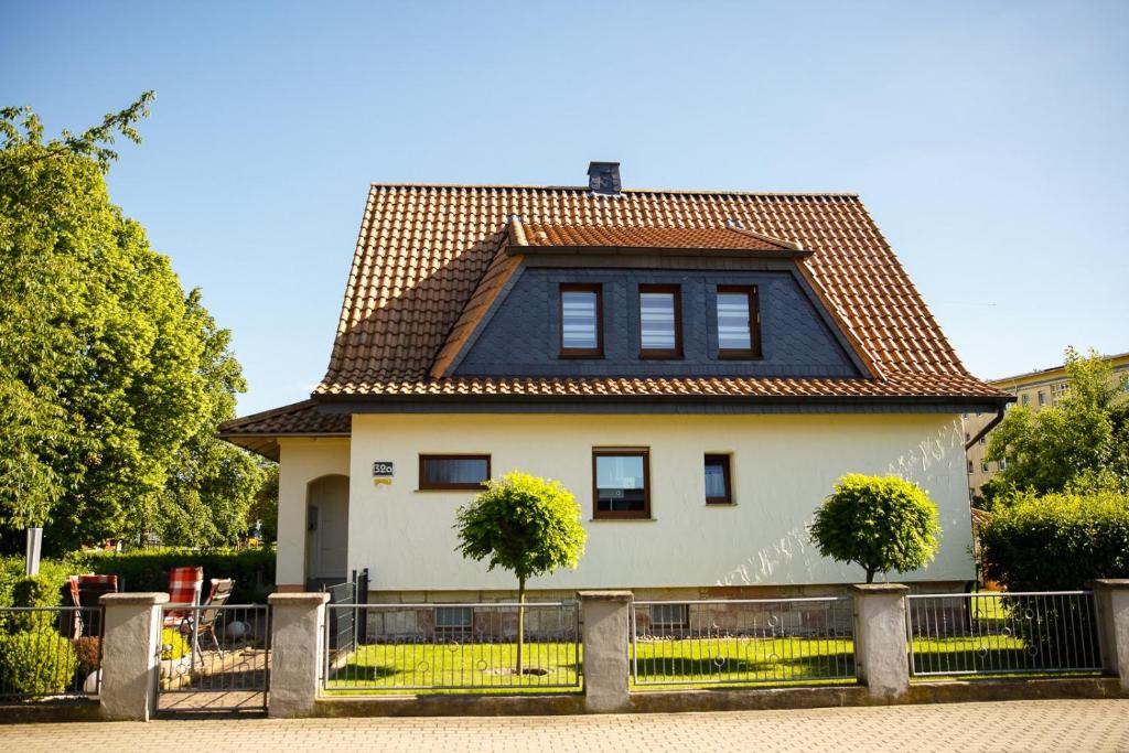 ein großes weißes Haus mit einem gefliesten Dach in der Unterkunft Ferienwohnung Ogger in Bad Salzungen