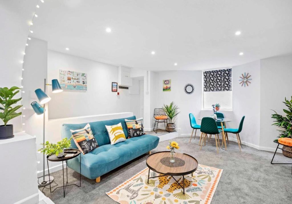 sala de estar con sofá azul y mesa en Queens Apartment - By My Getaways - Free Parking for one car, en Brighton & Hove