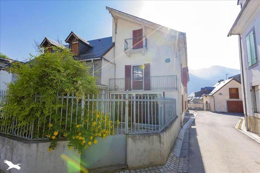 a white house with a fence on a street at Maison de 4 chambres avec vue sur la ville jardin clos et wifi a Esterre in Luz-Saint-Sauveur