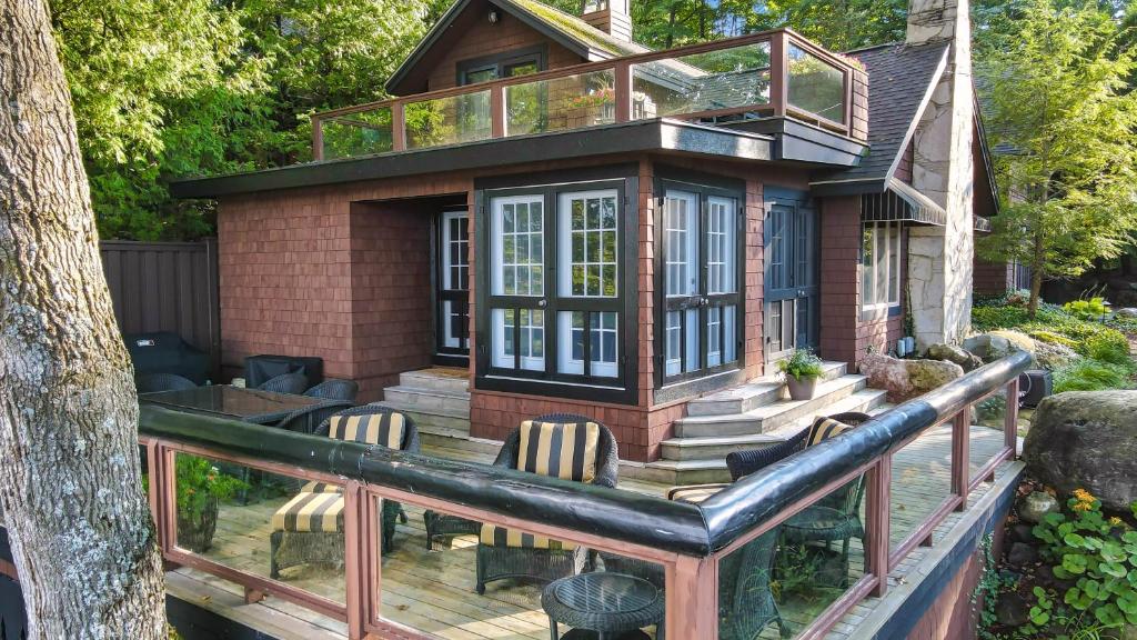 ein Haus mit einer Terrasse mit Stühlen darauf in der Unterkunft Black Duck Cottage in Charlevoix