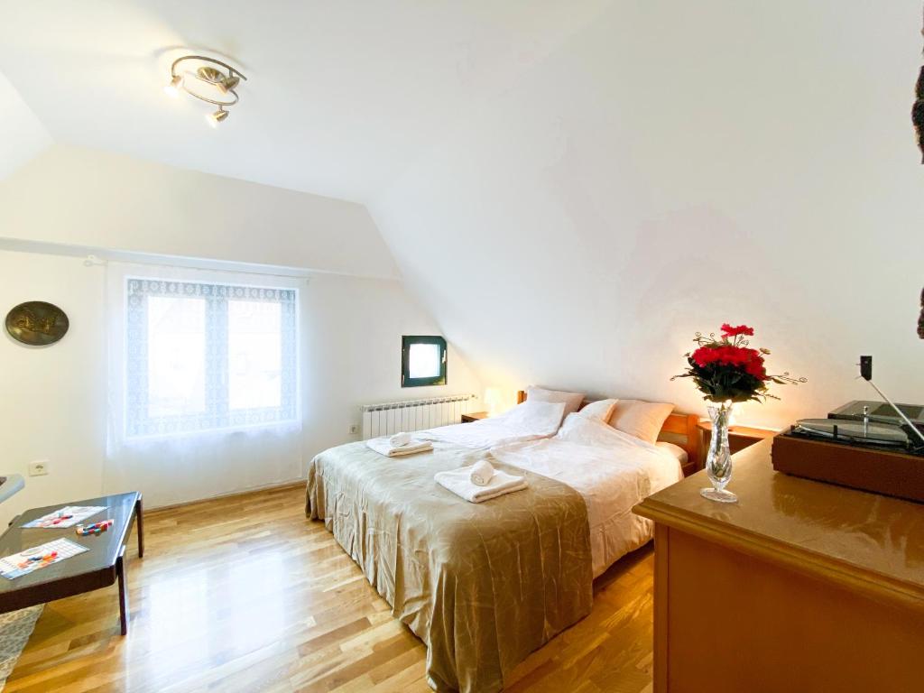 a bedroom with a bed and a vase of flowers at Apartment Mletačka in Zagreb