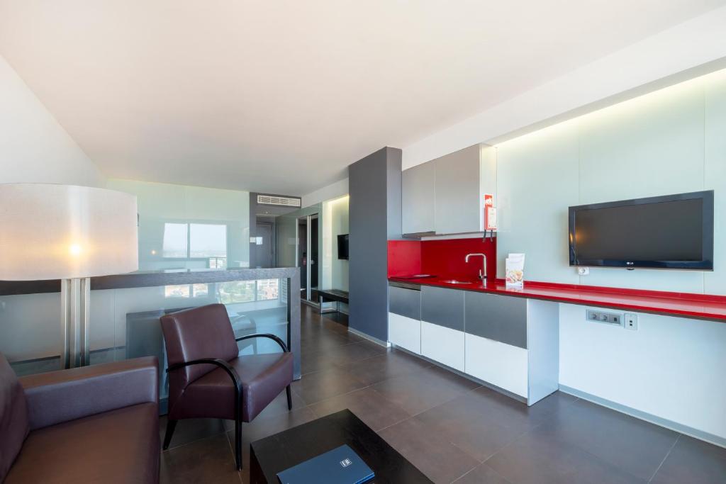 a living room with a red counter and a tv at RR Hotel da Rocha in Portimão