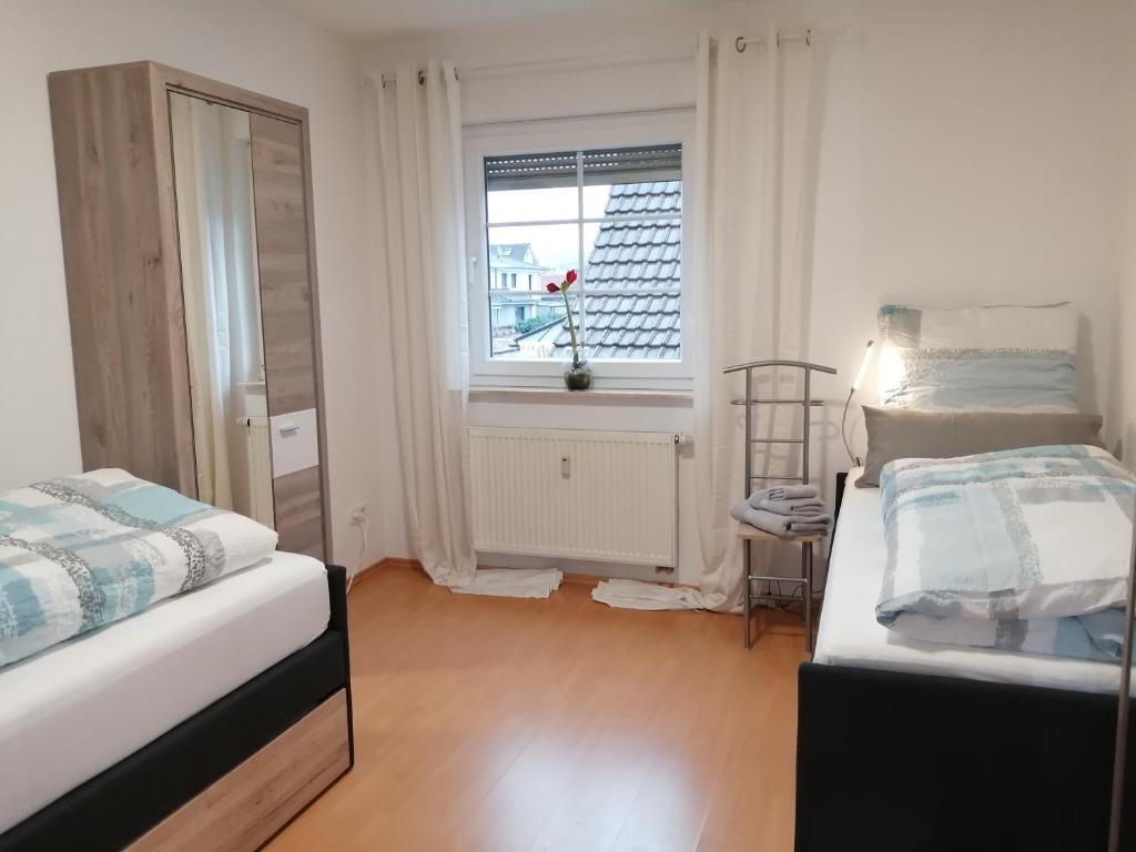een kleine kamer met 2 bedden en een raam bij Belle Etage geräumige Ferienwohnung mit Pool und Sauna in Lorsch
