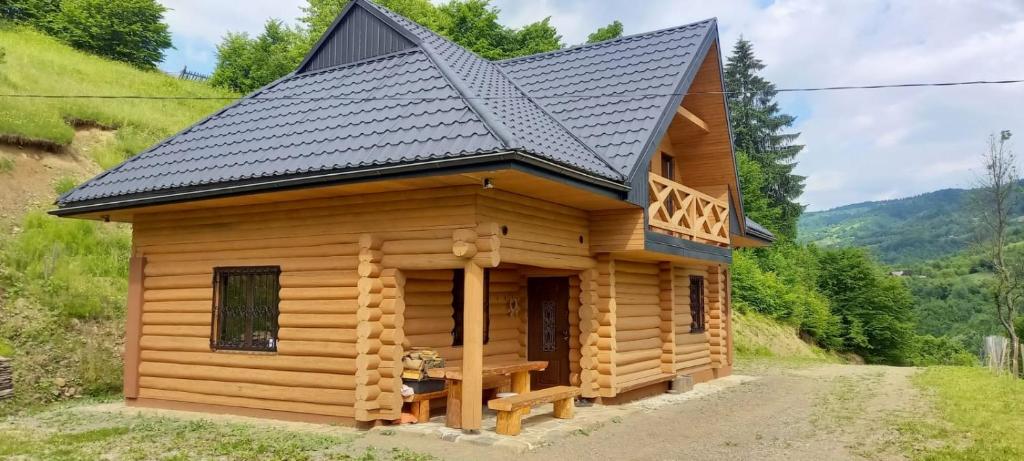 a log cabin with a black roof at Котедж Гук in Rakhiv