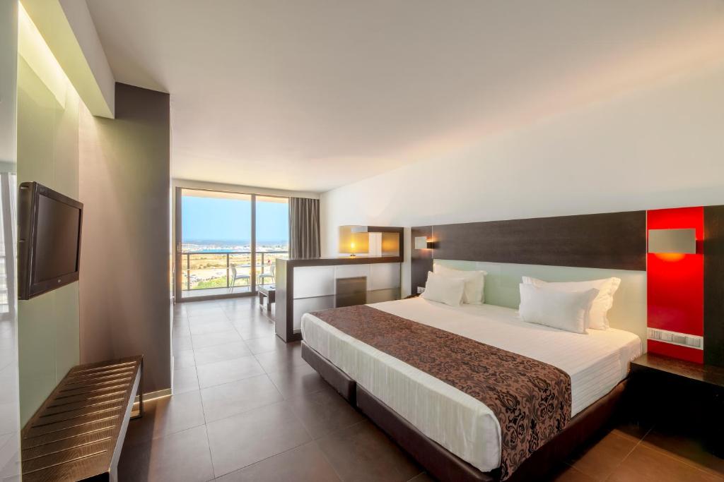 a hotel room with a large bed and a balcony at RR Hotel da Rocha in Portimão