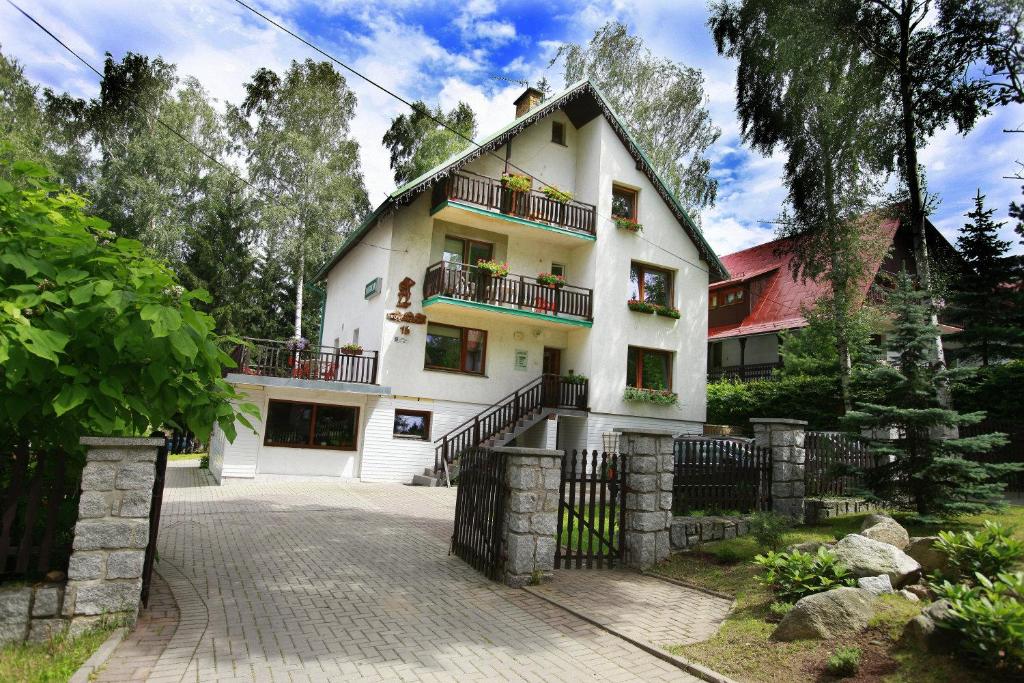 a large white house with balconies and a driveway at Willa Jawor in Karpacz