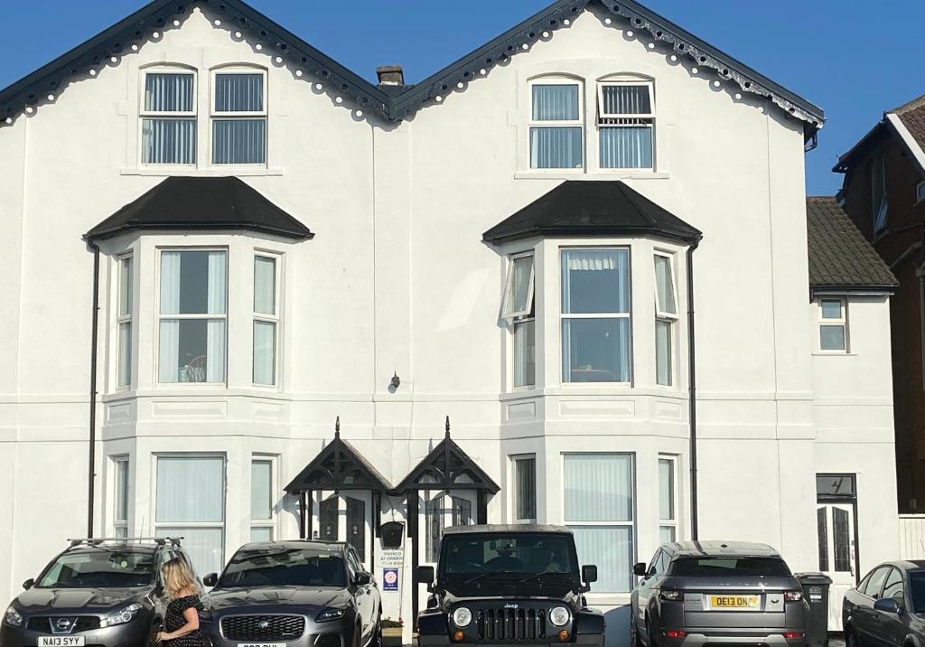 a white house with cars parked in front of it at The Kyrenia in Weston-super-Mare