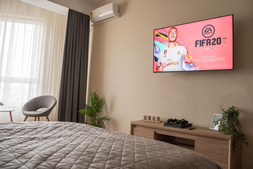 a bedroom with a flat screen tv on the wall at RentWill apartments Valley of Roses in Sectorul Botanica