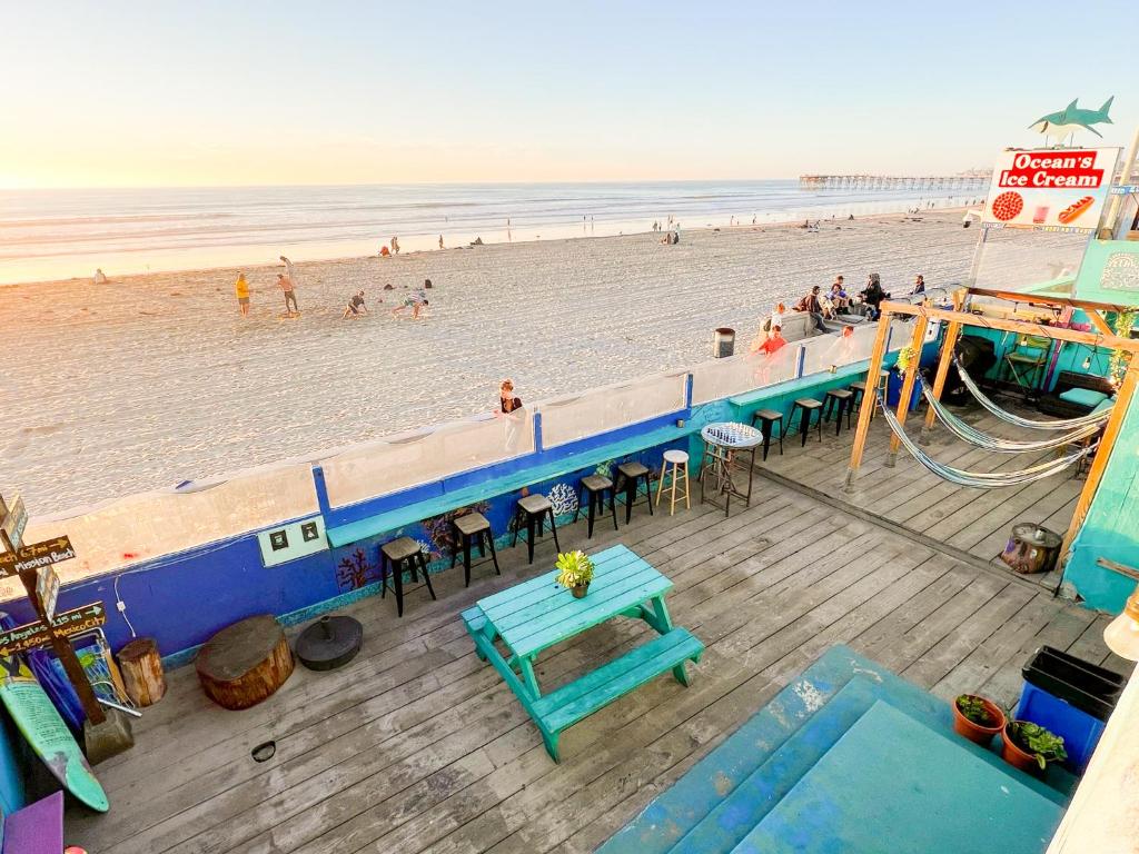una vista aérea de una playa con una mesa azul y bancos en ITH Beach Bungalow Surf Hostel San Diego, en San Diego