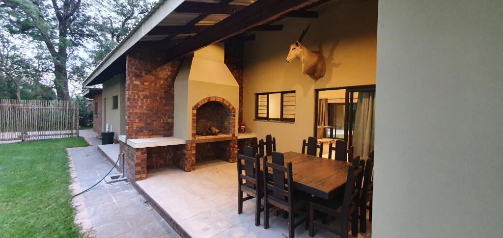 a patio with a wooden table and a fireplace at Honeybird self catering Accommodation in Hluhluwe