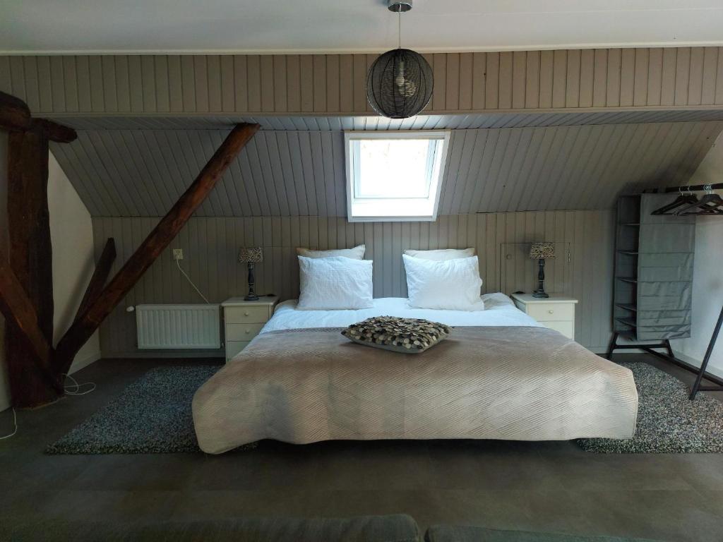 een slaapkamer met een groot bed op zolder bij Aekingahof in Appelscha