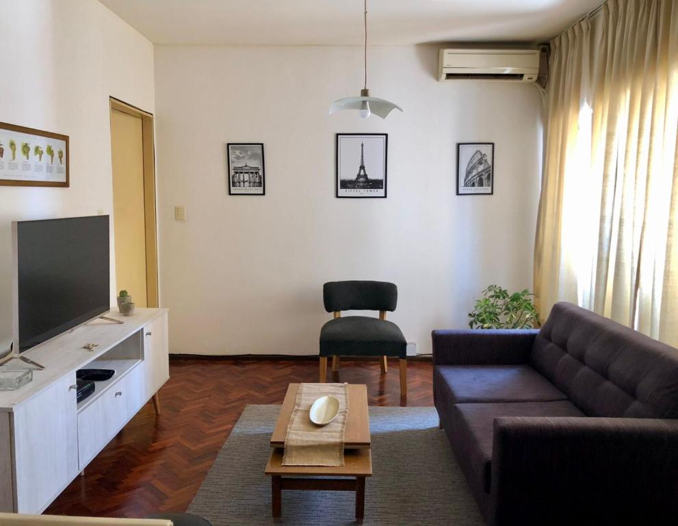 sala de estar con sofá y TV en Departamento en Ciudad de Mendoza en Mendoza