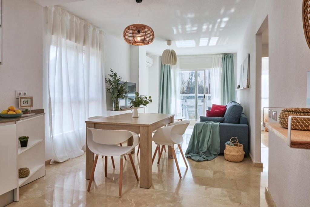 une cuisine et un salon avec une table et des chaises dans l'établissement Bright Sunny Albir Beach Apartment, à Albir