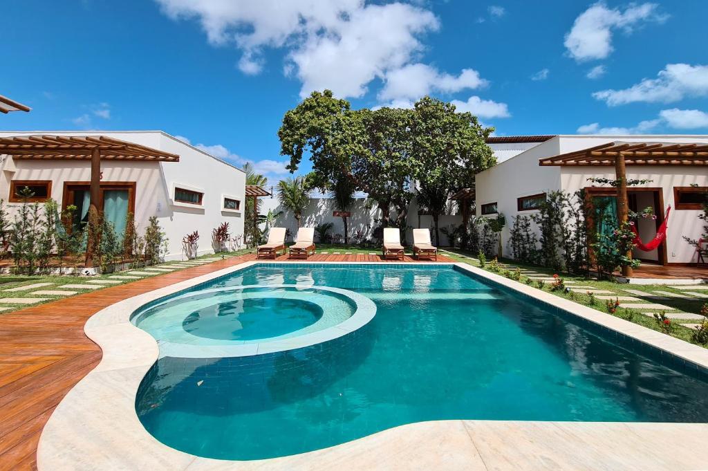 a swimming pool in front of a house at Kai'ala Pousada in São Miguel do Gostoso