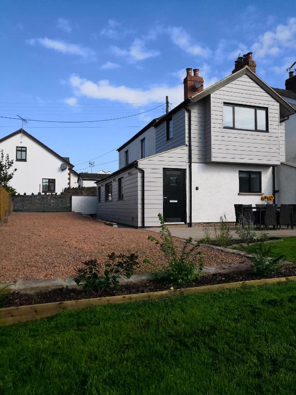 a white house with a driveway in a yard at Bowkett Cottage in Cinderford