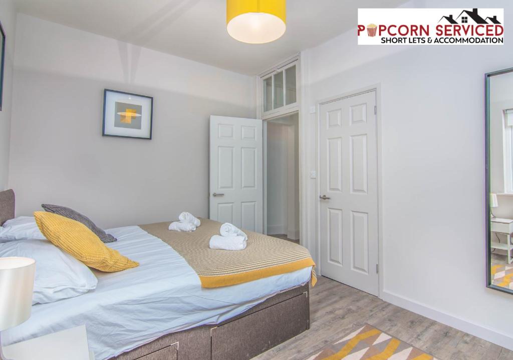 a bedroom with a bed with two towels on it at Monthly OFF - 6 Guest - 4 Beds - Free Parking by Popcorn Serviced Short Lets & Accommodation High Wycombe in High Wycombe