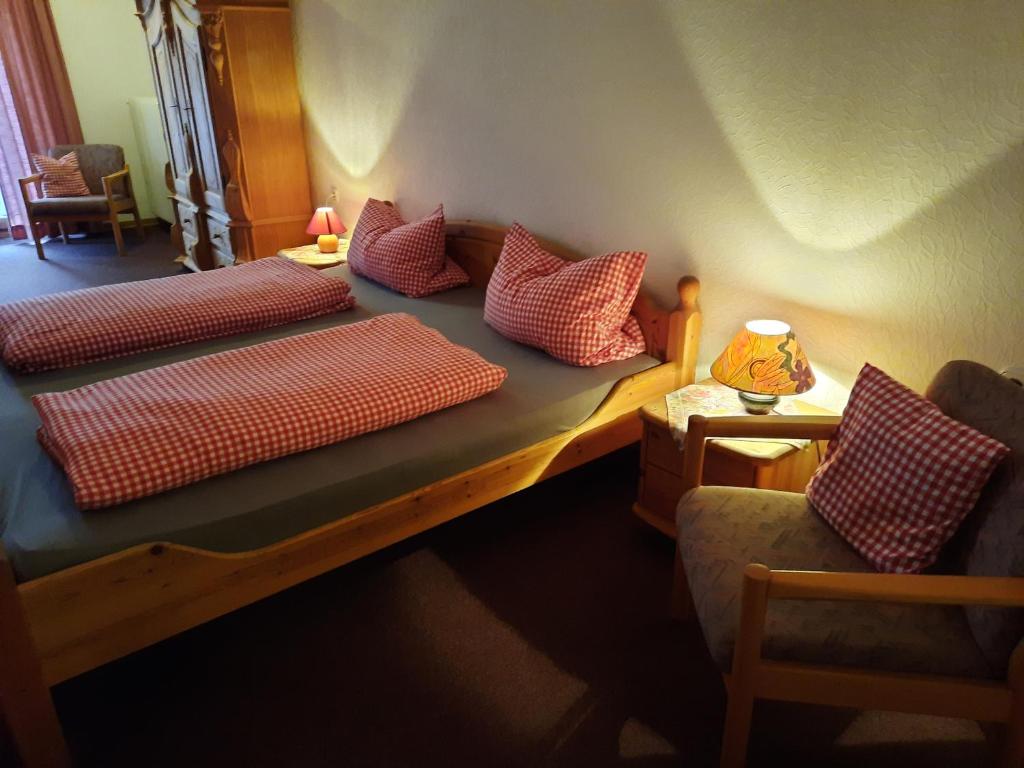 a bedroom with two beds with red and white pillows at Landgasthof Rotlipp Gästezimmer in Ortenberg