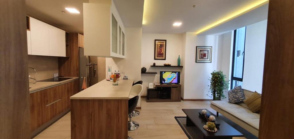 a kitchen and living room with a couch and a table at BlueZone Apartments in Quito