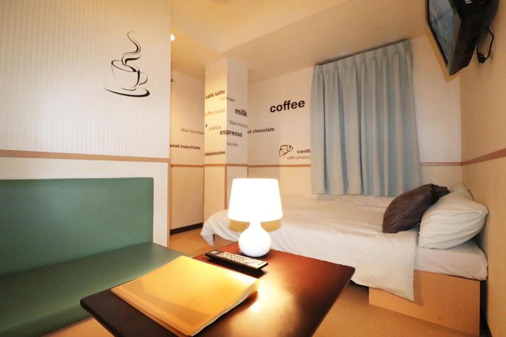 mały pokój z łóżkiem i stołem z lampką w obiekcie Hotel Yuyukan - Vacation STAY 10008v w Tokio