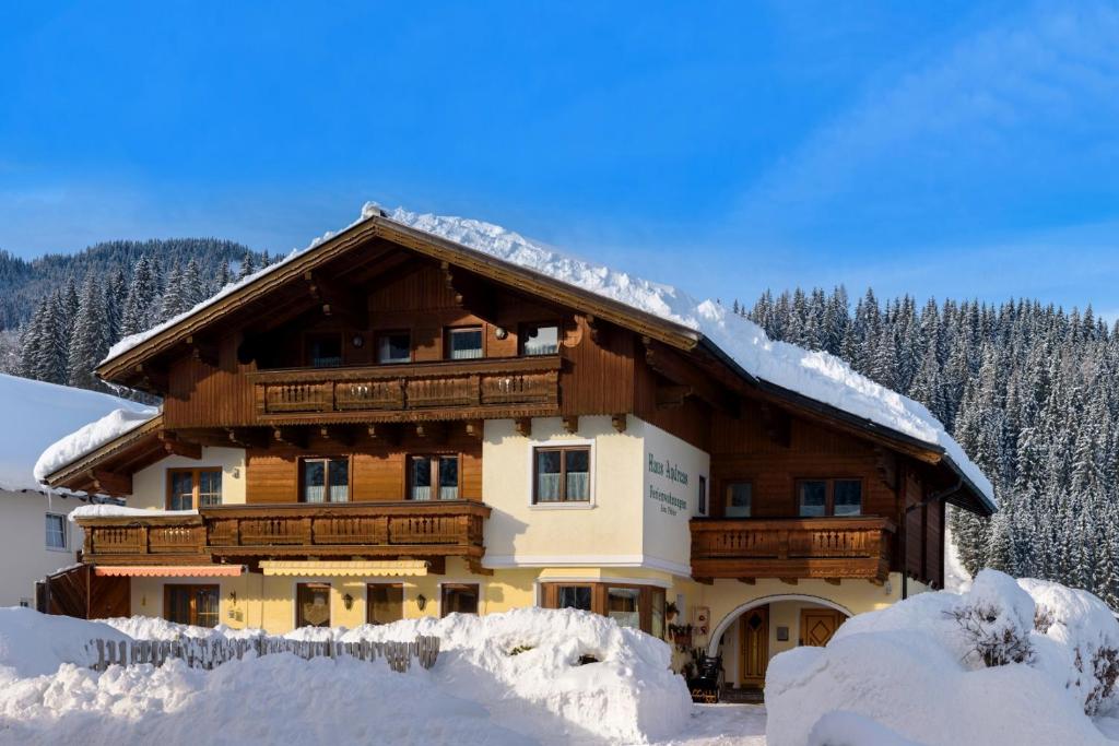 a large wooden house with snow on the roof at Ferienhaus Andreas in Flachau