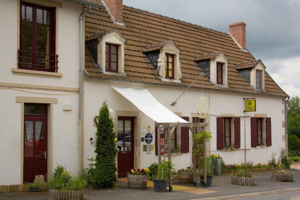 un bâtiment blanc avec un auvent blanc dessus dans l'établissement Au Coeur de Meaulne, à Meaulne