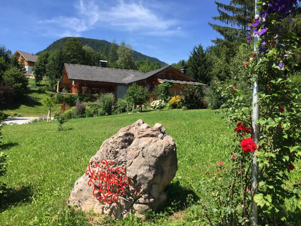 een rots in een tuin naast een huis bij Ferienwohnung Wildrose in Bad Mitterndorf