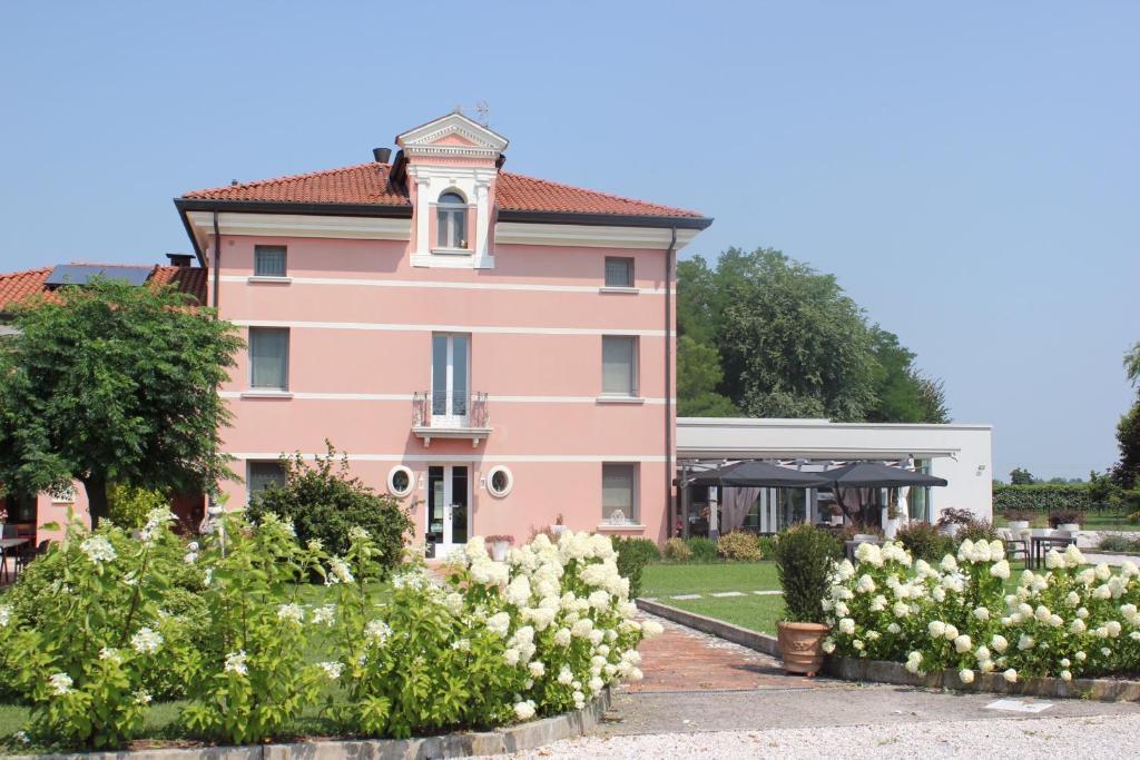 a pink building with white flowers in front of it at Villa Maria Luigia in San Biagio di Callalta