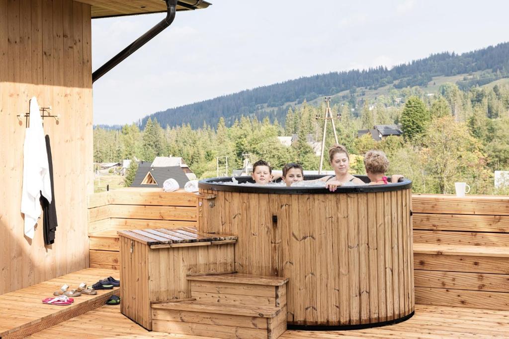 un grupo de niños en una bañera de hidromasaje en una terraza en Domki Fox House en Witów