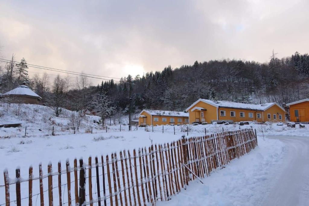 a fence in the snow next to a house at Fosseland Gjestegård in Feda