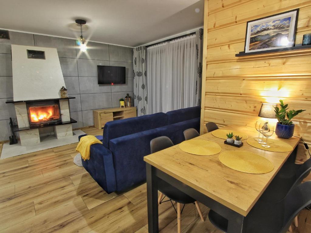 a living room with a table and a blue couch at Apartamenty Słodyczki in Nowe Bystre