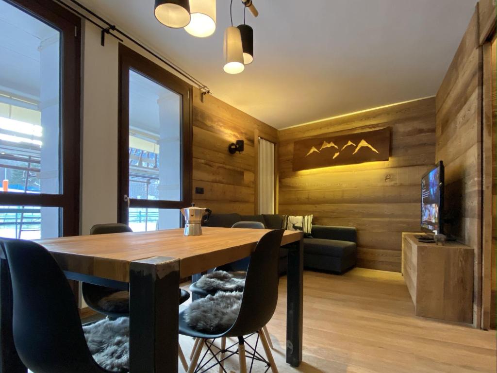 a dining room with a wooden table and chairs at Wooden House “Campo Smith” in Bardonecchia