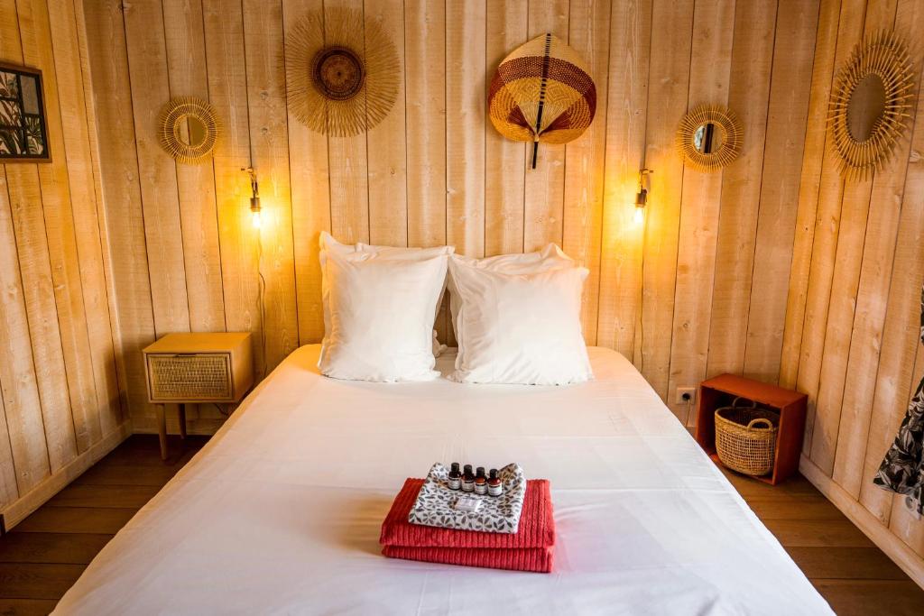 een slaapkamer met een wit bed en een rood dienblad bij La Villa Albatros in Lège