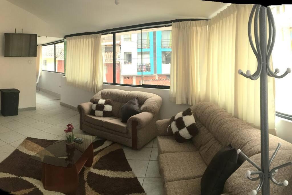 a living room with two couches and a large window at Apartamento independiente x6 RegenWasi in Cusco