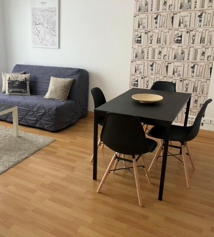 un salon avec une table, des chaises et un canapé dans l'établissement Centre ville avec garage - 4 personnes - Golbery, à Colmar