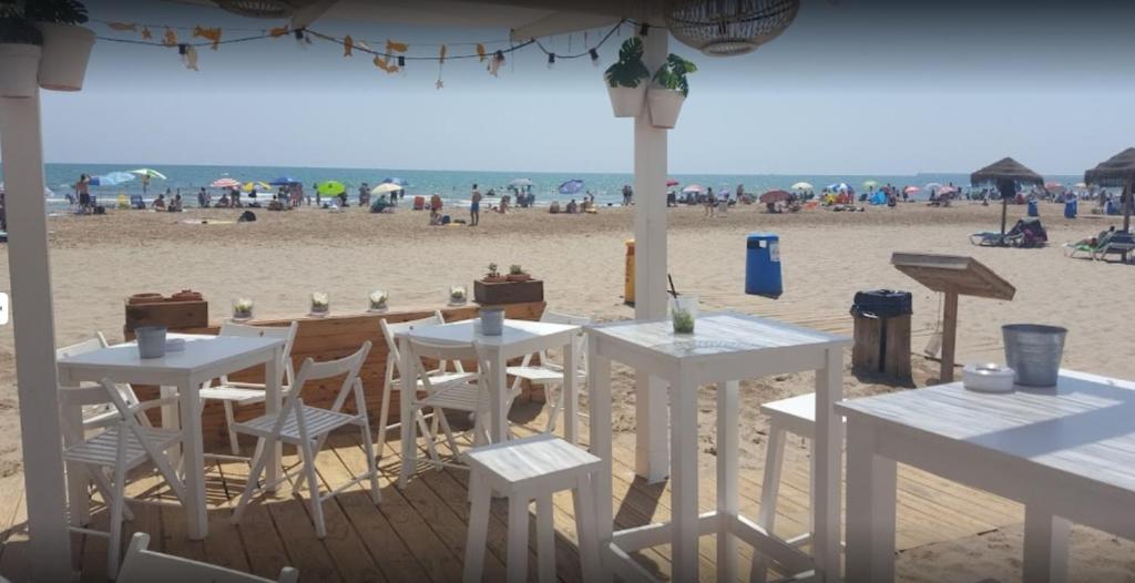 two white tables and chairs on the beach at BEACH VALENCIA 13 - Luxury Beachfront Apartament in Valencia