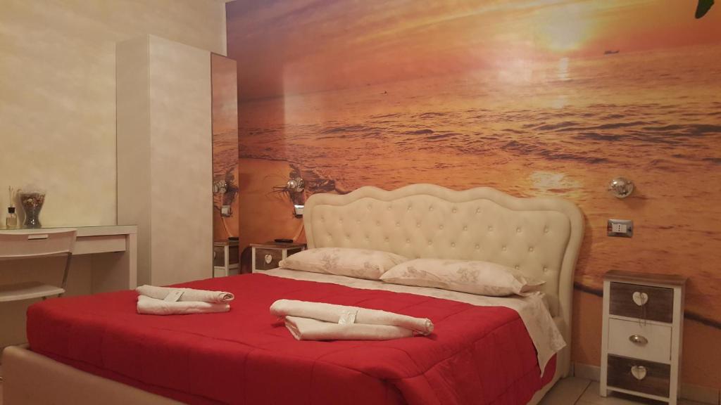 Un dormitorio con una cama roja con una pintura en la pared en Exclusive Passion, en Rho
