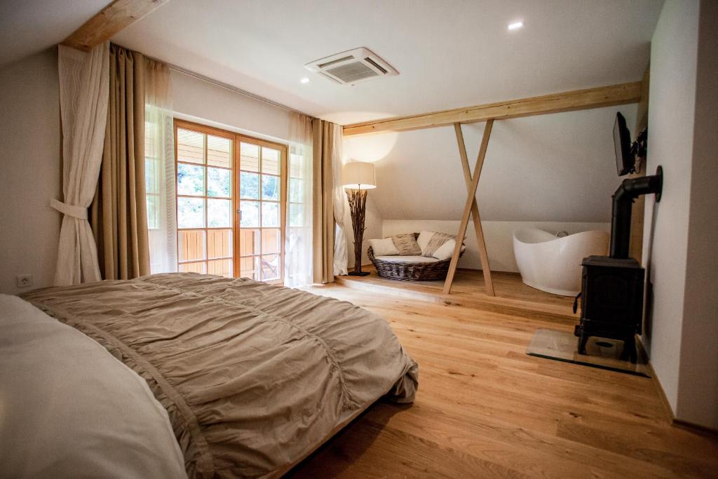 1 dormitorio con 1 cama y baño con bañera en Penzion Repnik en Kamnik