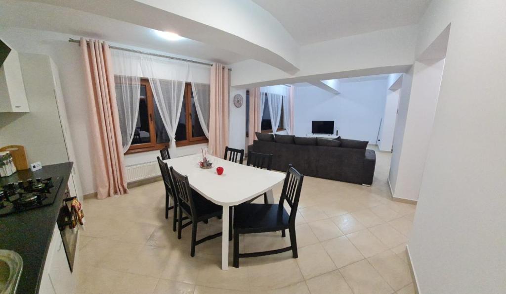 a kitchen and living room with a white table and chairs at apartament BEST VIEW in Buşteni
