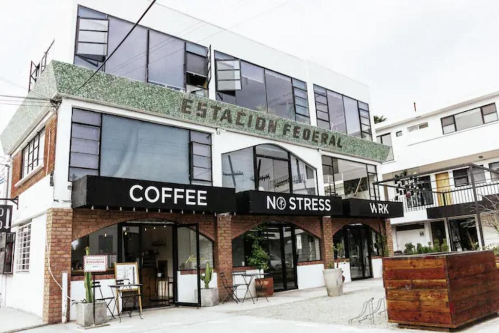 um café com uma placa na frente de um edifício em Coyote Lofts-Estacion Federal em Tijuana