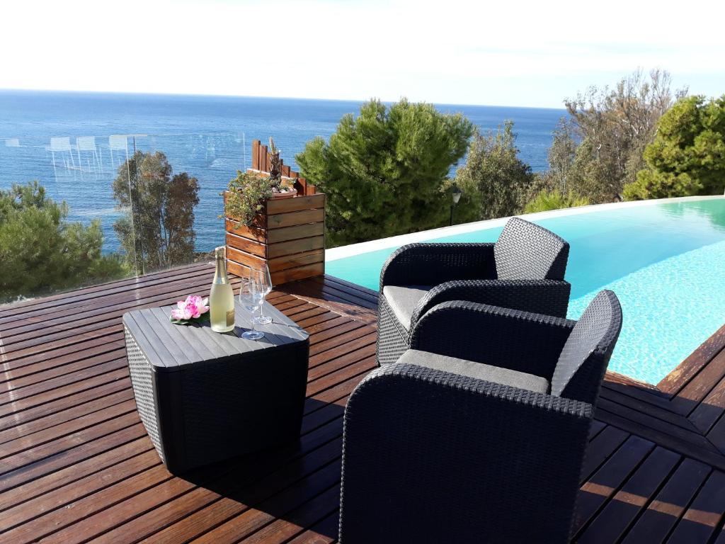 - une terrasse avec des chaises et une table à côté de la piscine dans l'établissement Villa Luxury Paradise Suites, à Salobreña