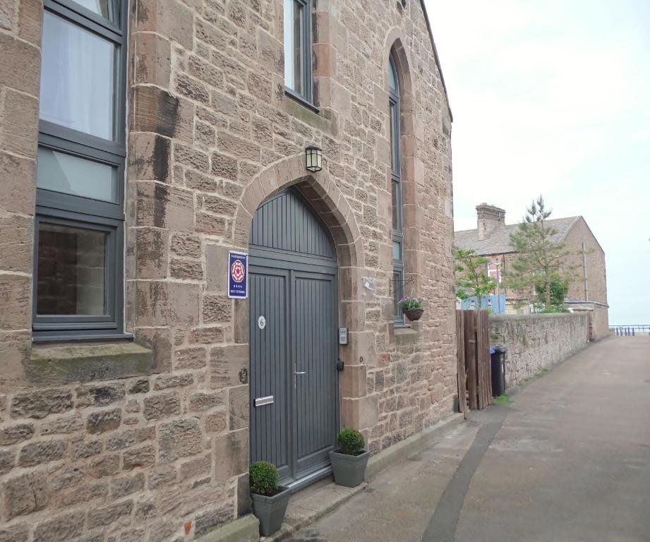 a brick building with a door on the side of it at Old Templars Cottage in Spittal