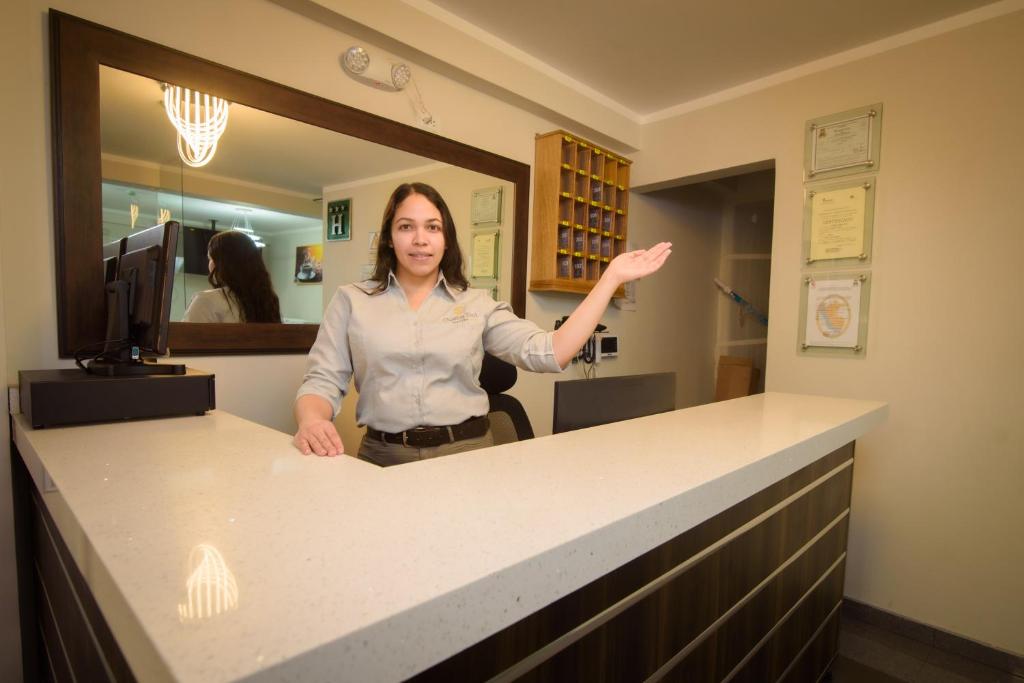 une femme se tenant derrière un comptoir dans un bureau dans l'établissement Hotel Costa Sol Moquegua, à Moquegua