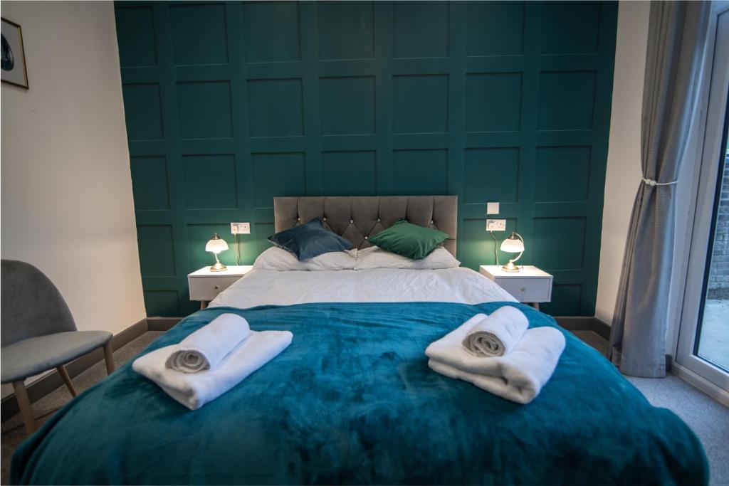 a bedroom with a large bed with towels on it at Cheerful 6 Bed with Hot Tub @ The Grey Elegance in Kent