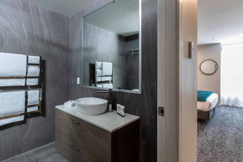 クイーンズタウンにあるQuest Queenstown Apartments Remarkables Parkの洗面台と鏡のあるバスルーム