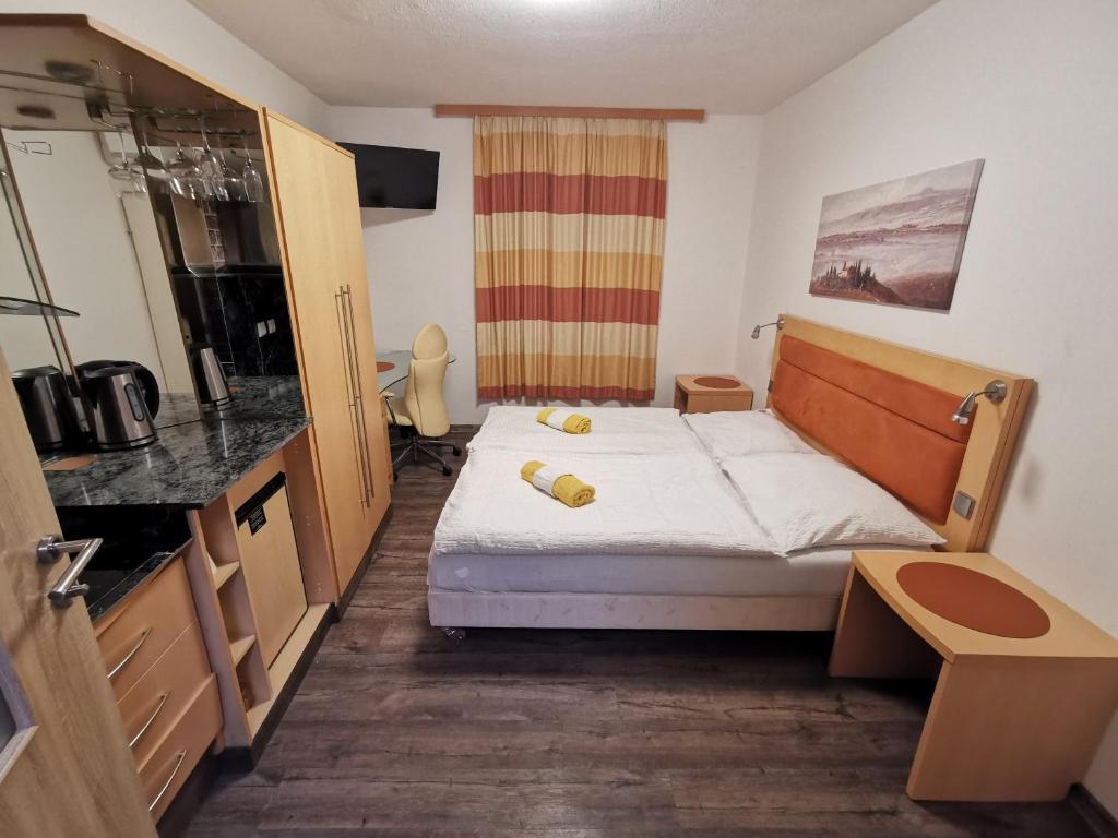 a small room with a bed and a kitchen at Cesar's Pension in Föhrenhain